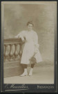 Mauvillier, Emile. Jeune fille en robe blanche tenant un bouquet, appuyée sur une balustrade