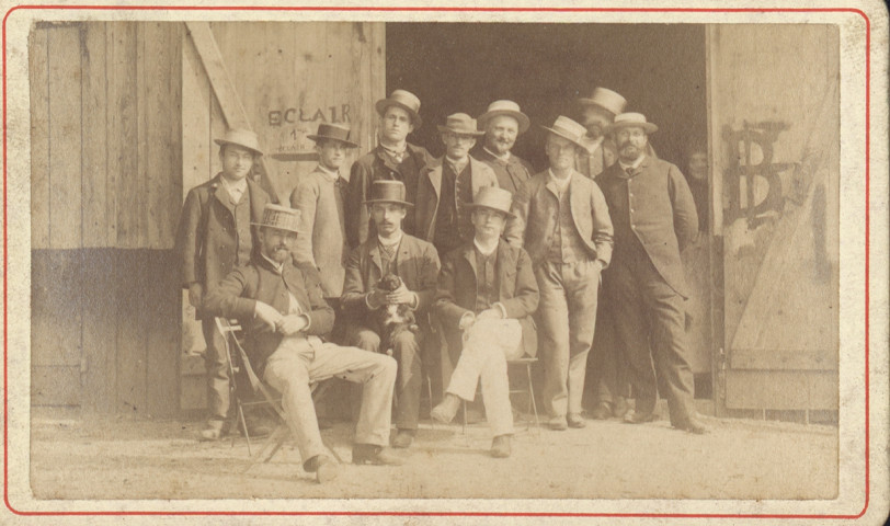 Photographie de groupe de sociétaires devant le hangar en bois au Près-de-Vaux.