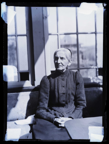 Portrait de femme âgée assise sur un divan