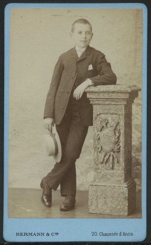 HERMANN et Cie. Garçon debout adossé à une colonne
