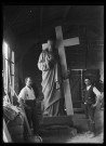 Deux praticiens de Louis Hertig posant dans un atelier autour du Christ portant la Croix du monument aux morts de Trévillers