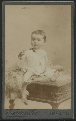 Mauvillier, Emile. Bébé assis sur un meuble, avec une fourrure