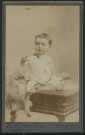 Mauvillier, Emile. Bébé assis sur un meuble, avec une fourrure