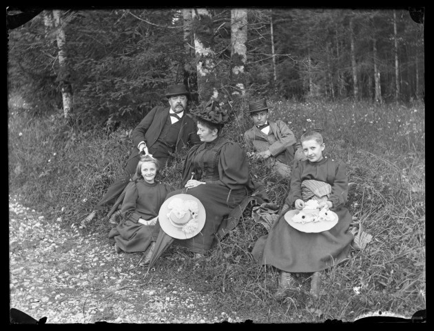 Portrait de famille représentant Emile Ledoux, son épouse Aimée et trois de leurs quatre enfants (Henri, Valentine et Geneviève) posant sous un arbre lors d'une promenade en forêt.