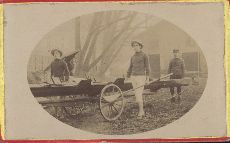 Photographie de quatre canotiers avec leurs embarcations ; près du hangar en bois des Près-de-Vaux.