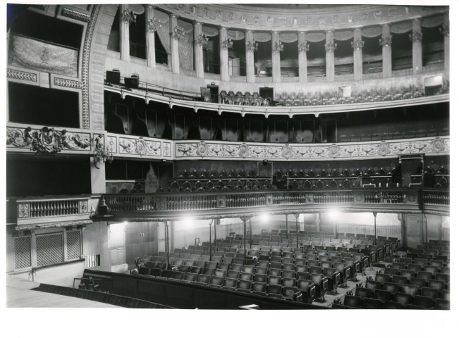 Théâtre municipal : 3 photographies en noir et blanc (2 en doubles exemplaires) de la salle avant l'incendie de 1958 ; 18 photographies en noir et blanc du bâtiment, de la toiture, de la salle, de la scène et des coulisses après sa reconstruction en 1959 (1959) ; factures (1990-1991).
Dépôt de décors du théâtre au 1 rue Mairet, réfection de la couverture : dossier de marché n°107 de 1988, plans (1988).