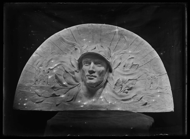 Elément de monument commémoratif dans l'atelier : tête laurée de soldat dans une demi-lune