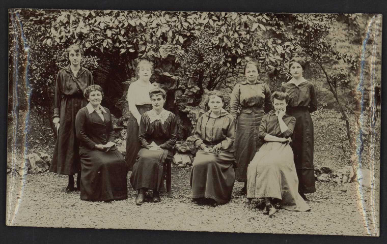 Personnel de l'école ménagère Jeanne d'Arc : photographie de groupe noir et blanc prise dans le jardin [1912 environ].