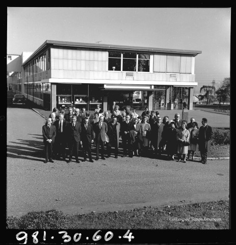 39MDT412 - Photographie de groupe du personnel prise devant l'entrée administrative de l'usine de Palente : négatif (noir et blanc).
