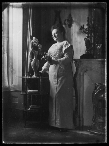 Femme debout arrangeant des fleurs dans un vase