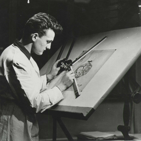 2MDT7 - Portrait de Roland Guerber, dessinateur du prototype de montre Lip R148 à son poste de travail : photographie noir et blanc.